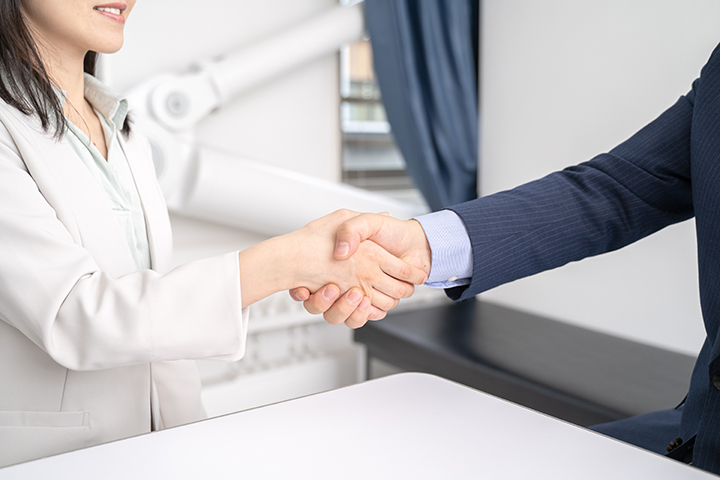 経営者と社員が握手をしている